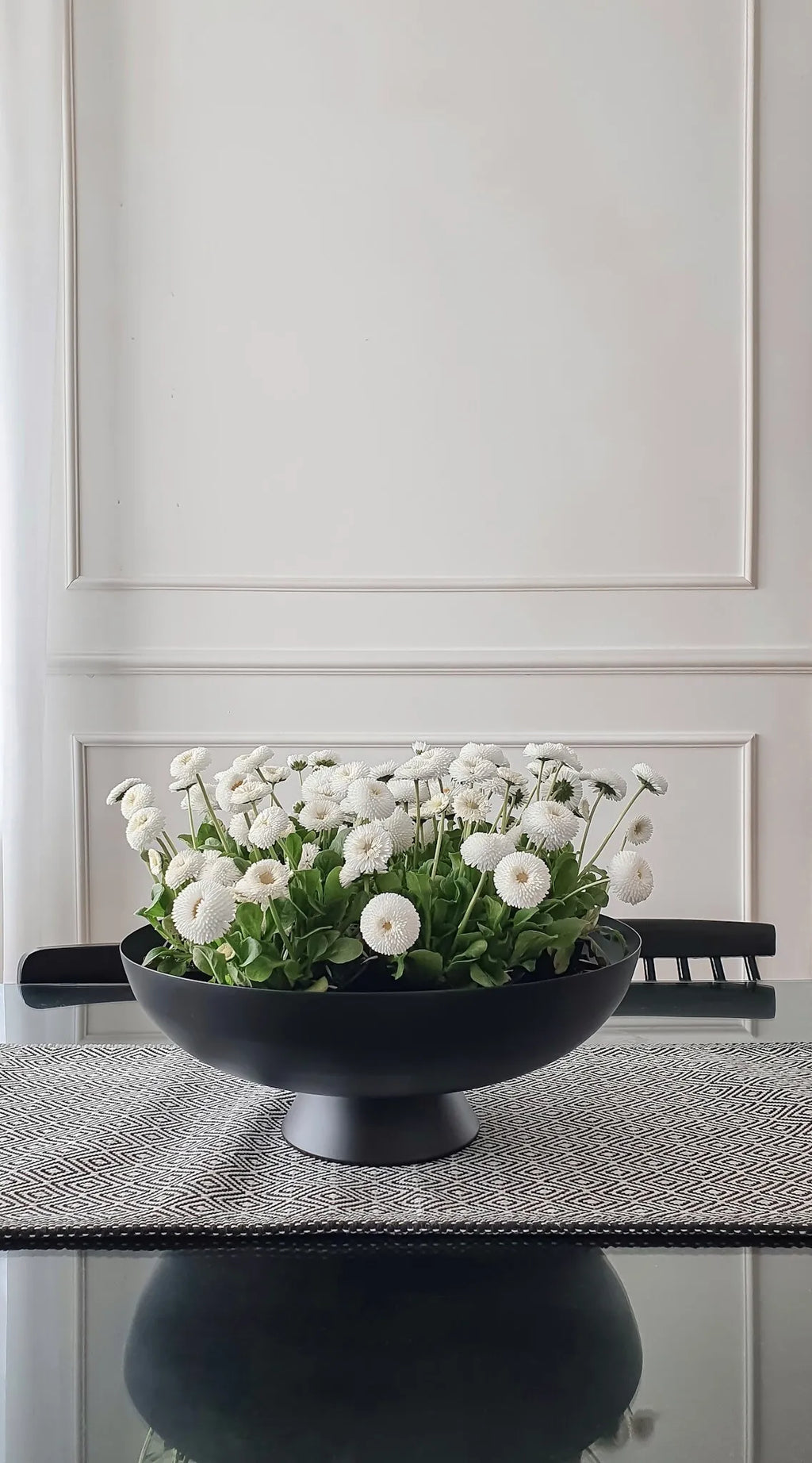 table with vase and white wall panelling in background