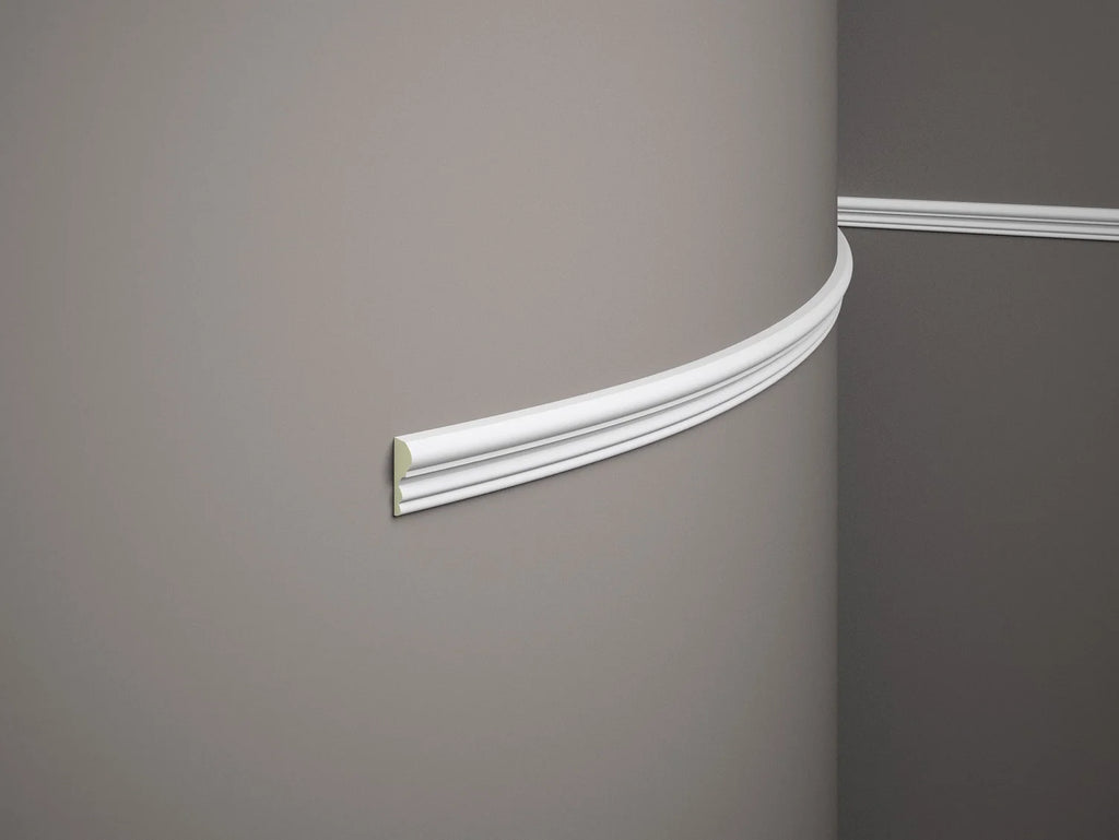 Close-up of a decorative cornice on a plain wall.