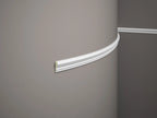 Close-up of a decorative cornice on a plain wall.