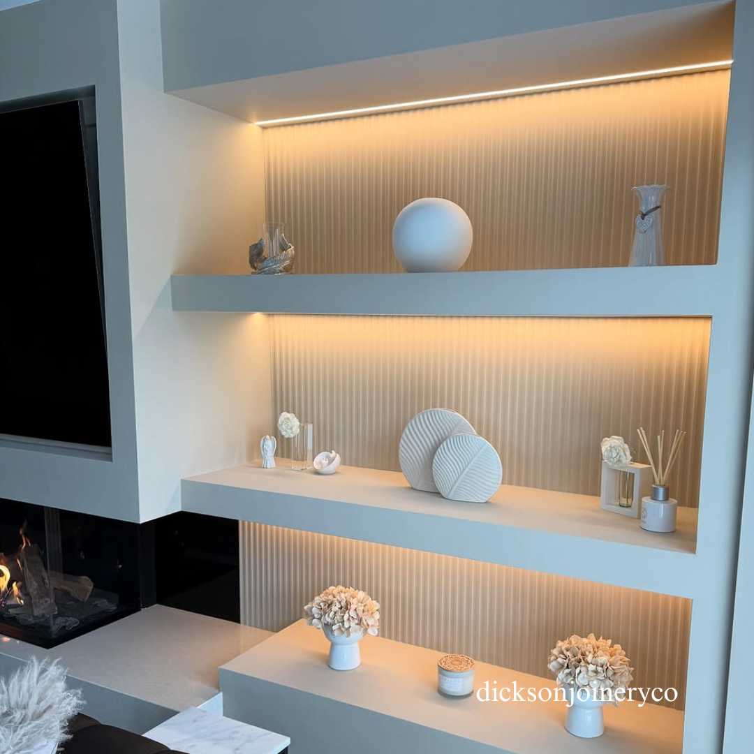 Modern living room with panelled shelves displaying decorative items and a fireplace.