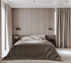 Modern bedroom with wall panelling, a bed, headboard, and decorative elements.