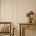 A neatly arranged room featuring Wide Tongue & Groove Wall Panels with vertical grooves on a chair and wall, a wooden table, and a vase with dried flowers.
