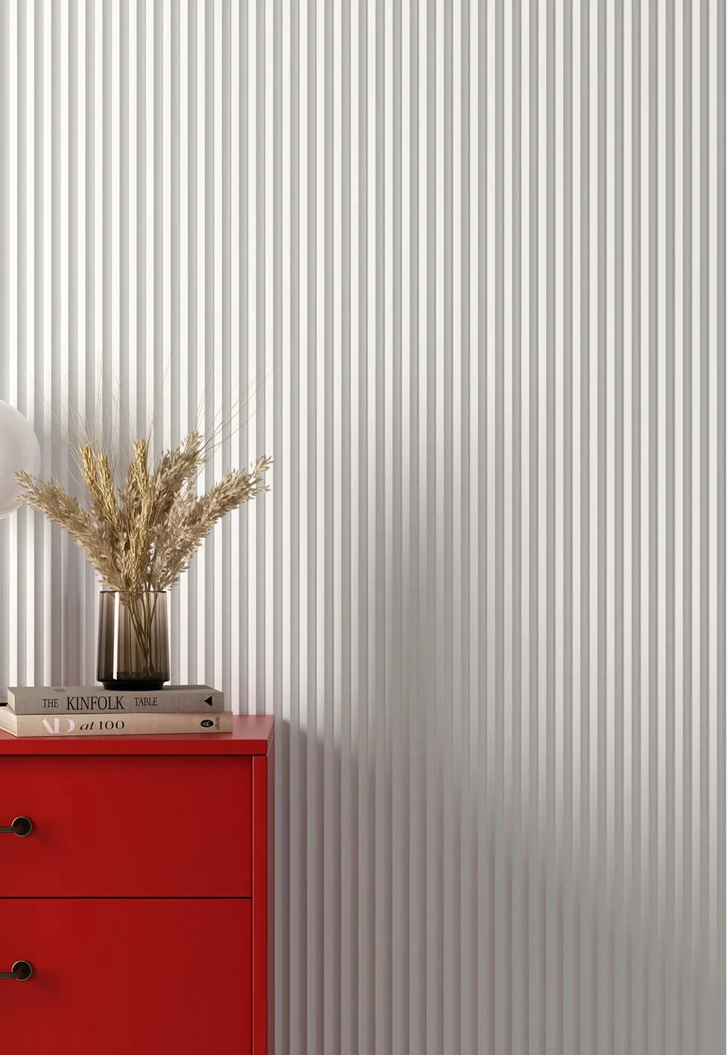 Red cabinet with a vase of wheat against white wall panelling