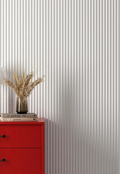 Red cabinet with a vase of wheat against white wall panelling
